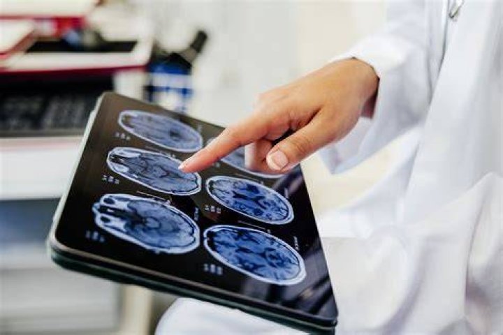A doctor pointing to a computer screen showing a scan of Travis Barker's dislocated finger.