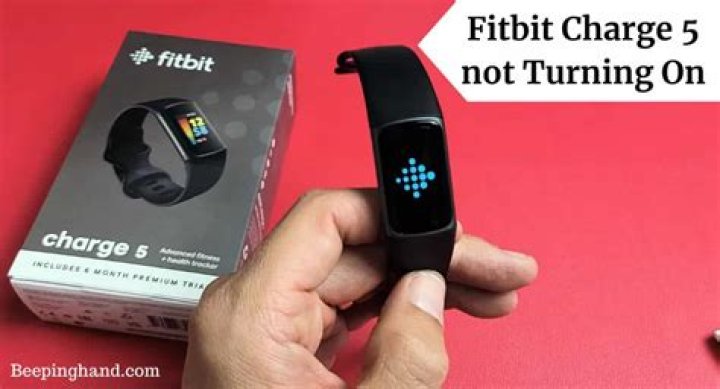 A Fitbit Charge 5 on a man's wrist displays a Fitbit Pay screen.