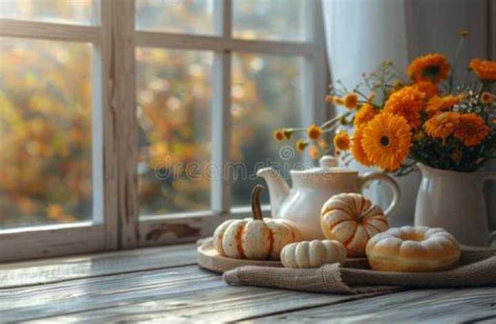 A windowsill decorated with a mortar and pestle, small ingredients, and a basket