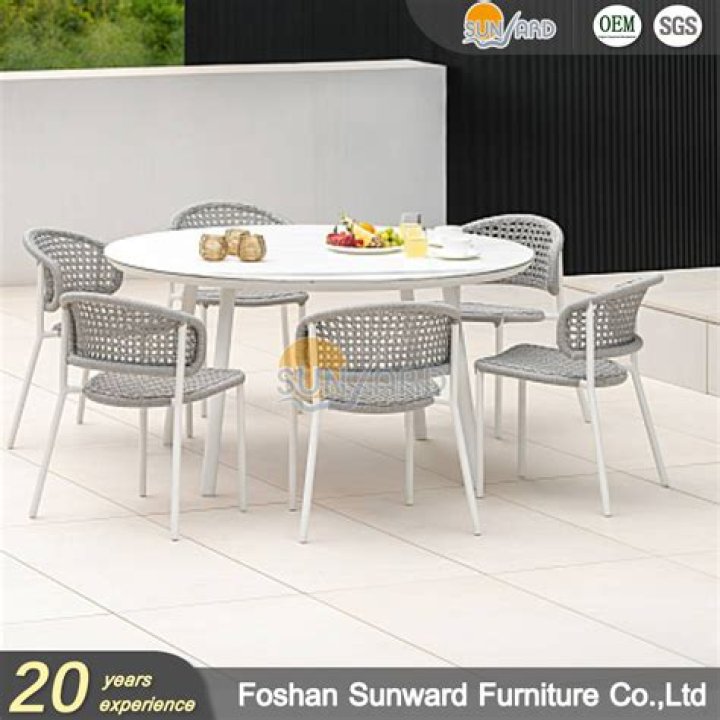 An outdoor dining table surrounded by cushions and streamers