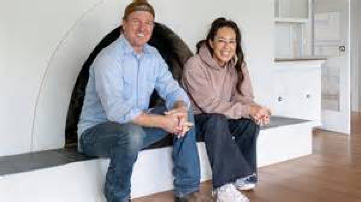 chip and joanna gaines sitting on front steps of house