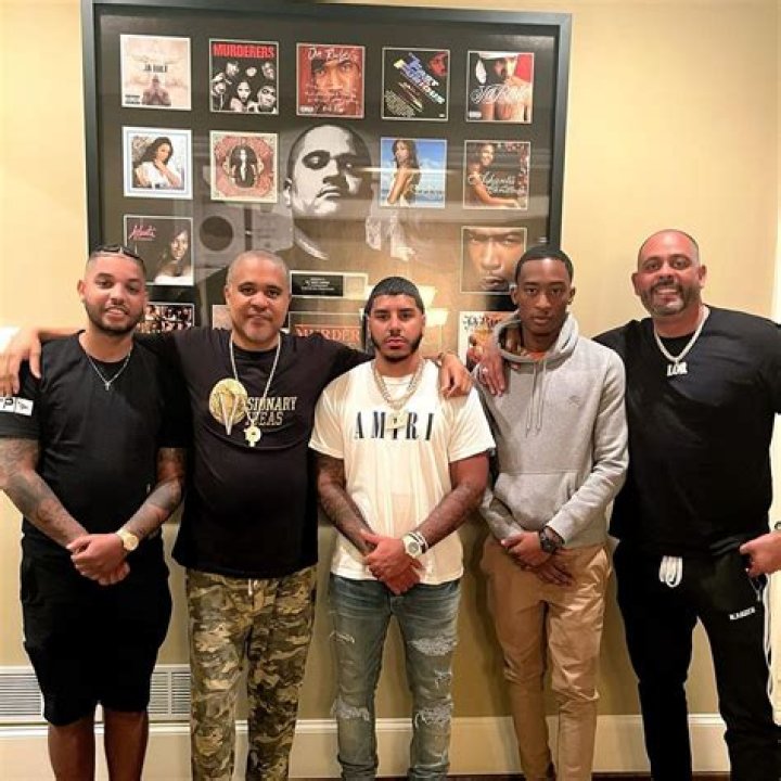 Irv Gotti posing with four other men in studio side by side.
