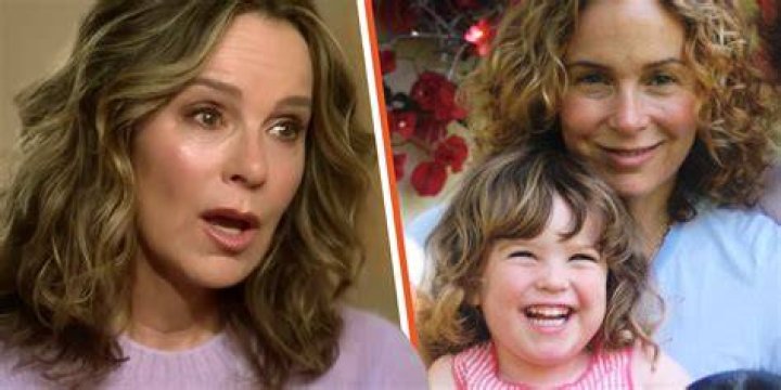 Jennifer Grey looking down as she walks outside