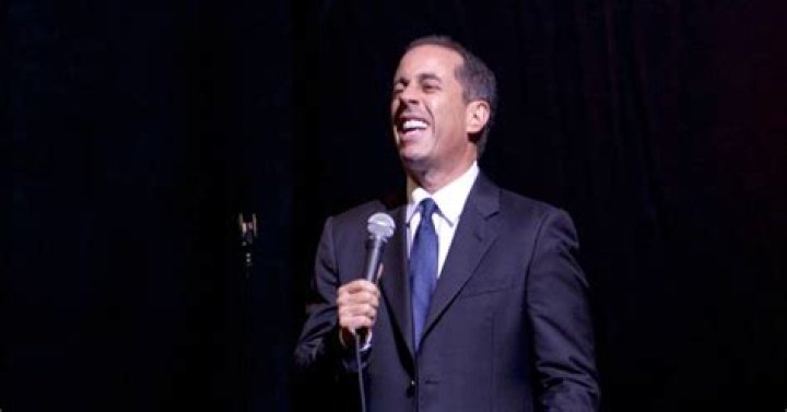 Jerry Seinfeld laughing while performing standup comedy