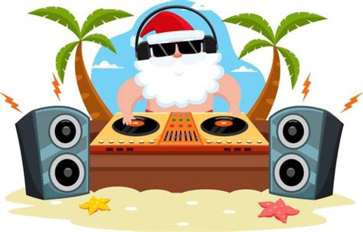 Someone DJing on a beach near dozens of people