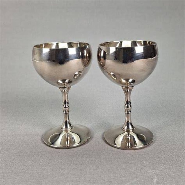 Two silver goblets full of grapes